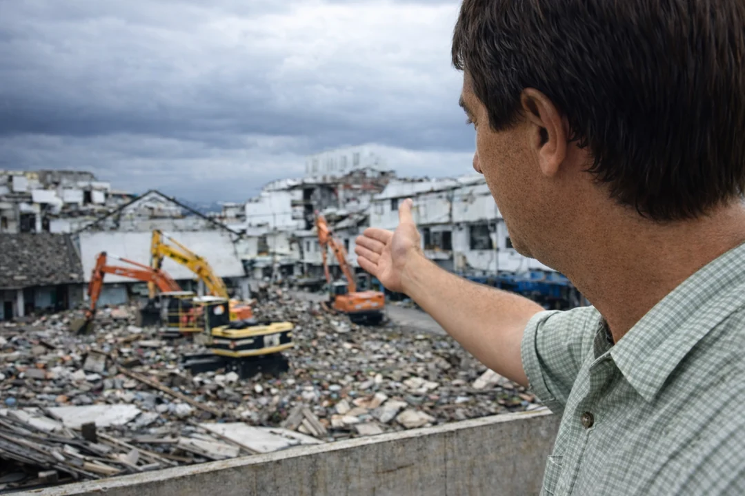 David surveying Banda Aceh reconstruction, pointing at construction